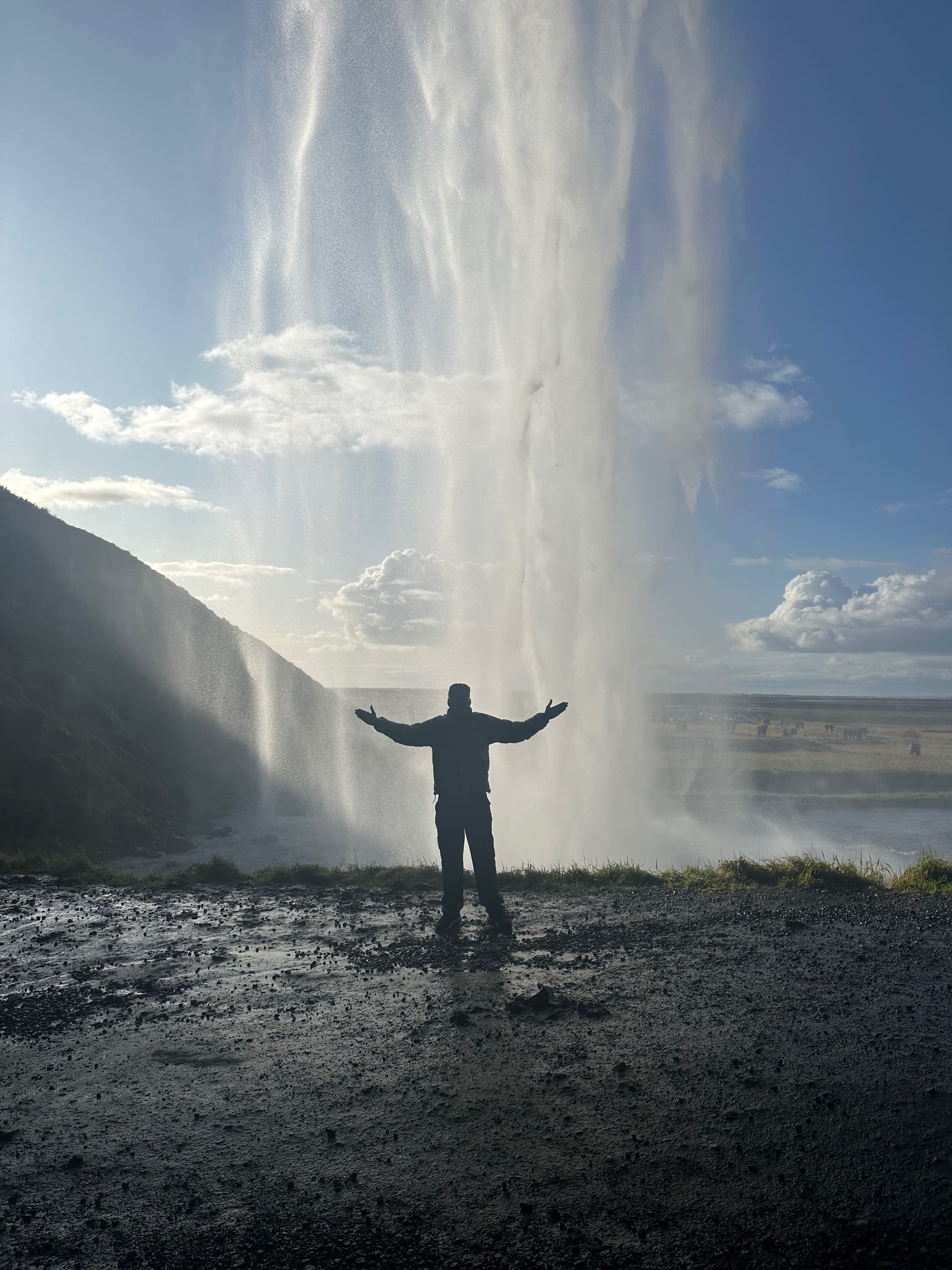 Standing beneath Seljalandsfoss waterfall, Iceland